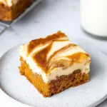 Delicious carrot cake cheesecake bars topped with cream cheese frosting.